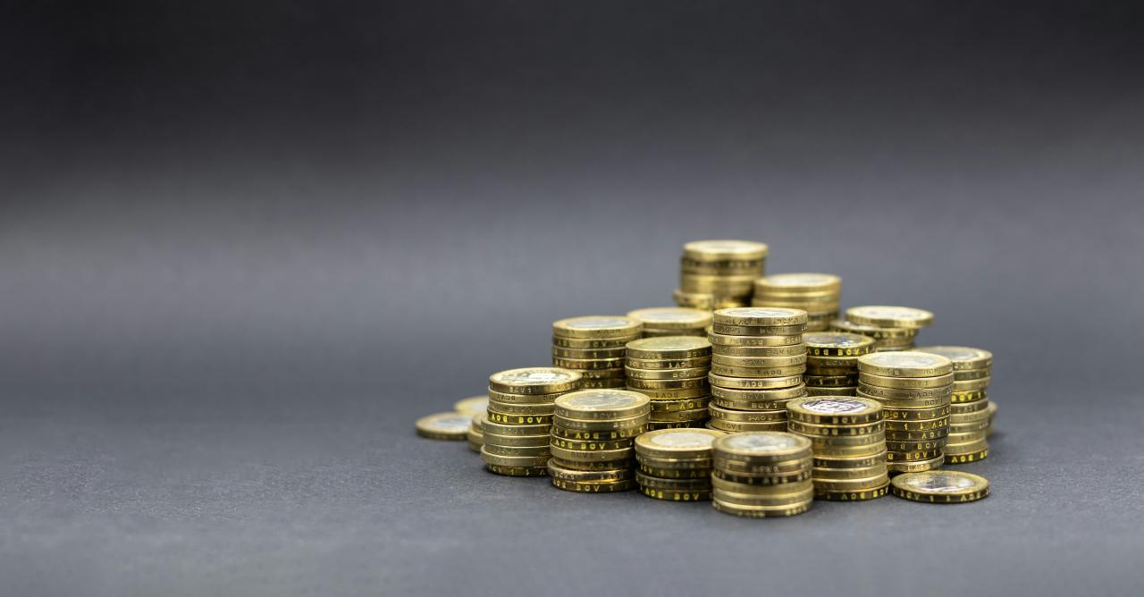 Tumpukan koin emas dengan latar belakang gelap